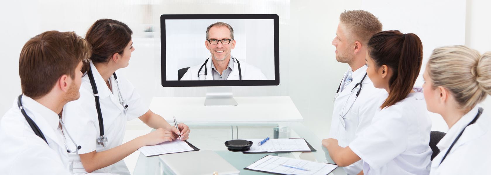 28321431 – team of doctors attending video conference at desk in hospital